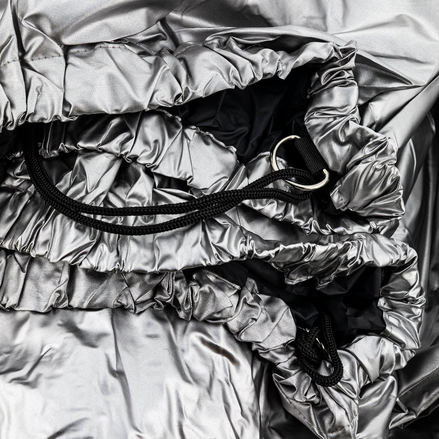 Close-up of a silver spartan mower cover with black straps