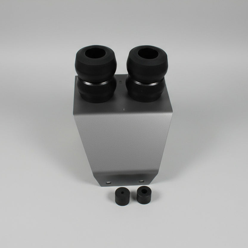 White rectangular block with black cylindrical components on a gray tiled floor