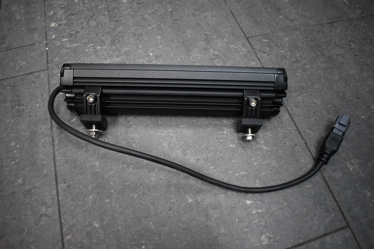 Black LED light bar on a gray floor