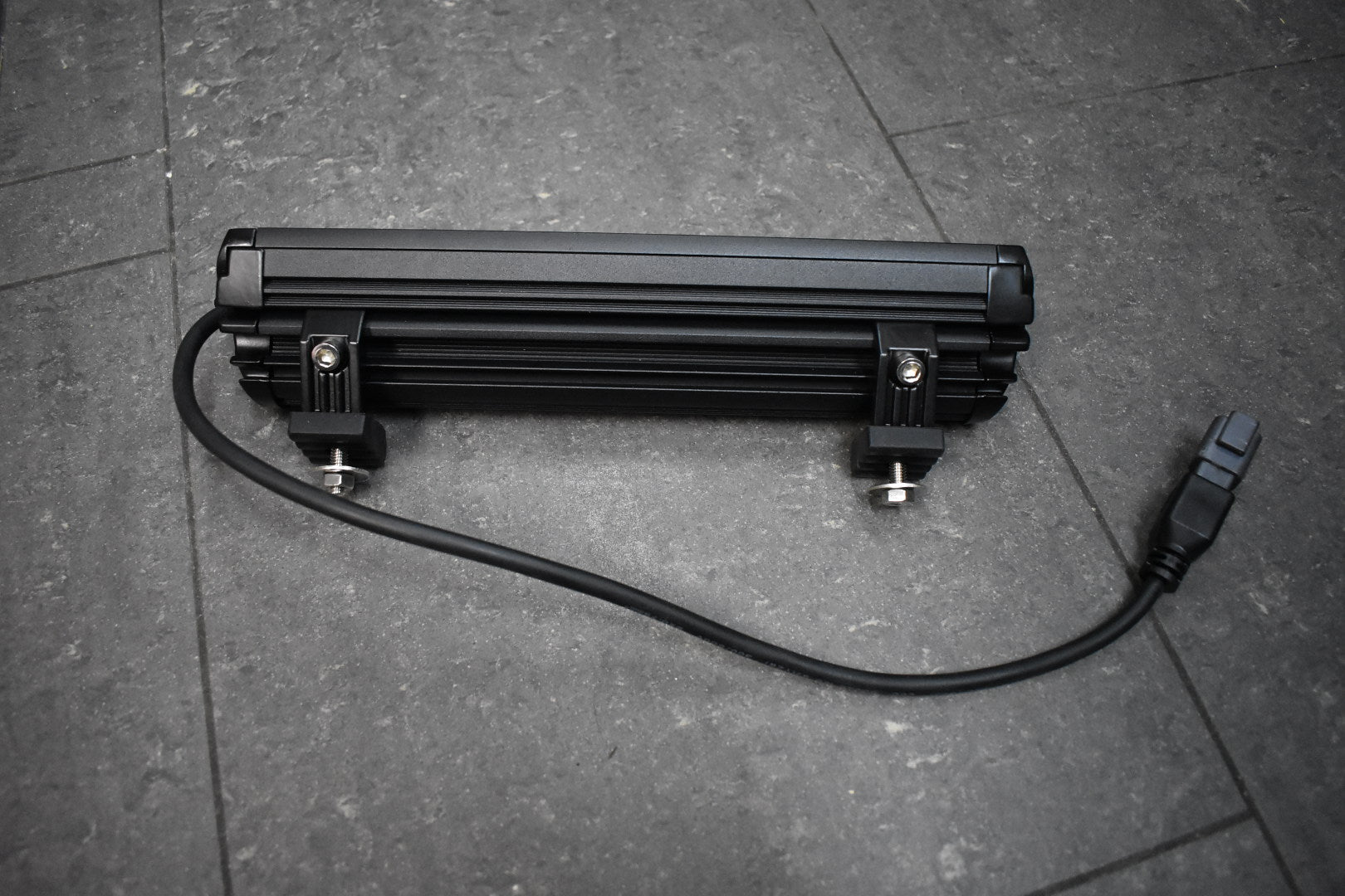 Black LED light bar on a gray floor