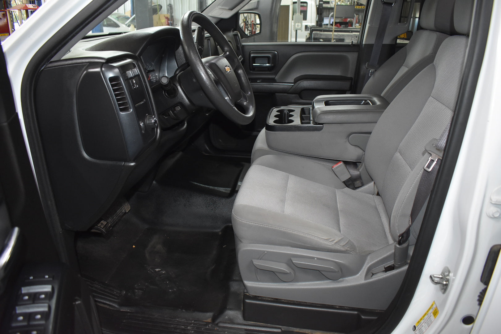 Interior of a vehicle with gray seats and black dashboard.