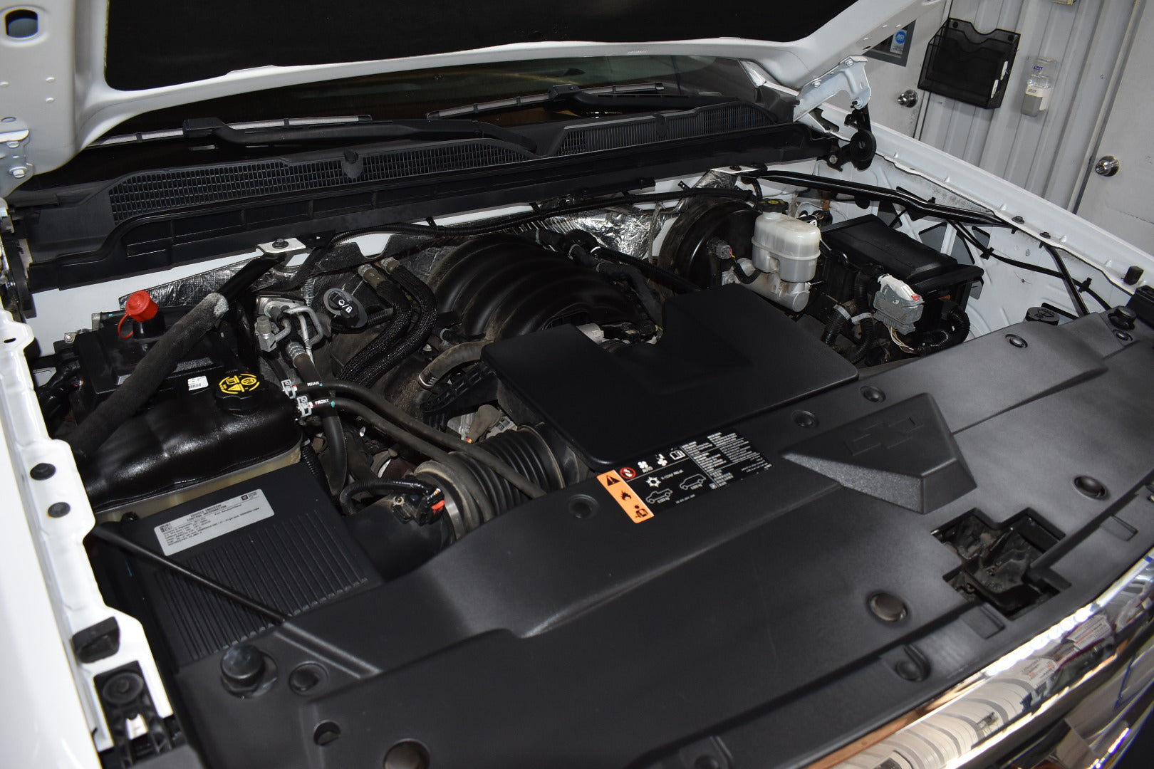 Open hood of a vehicle showing the engine compartment.