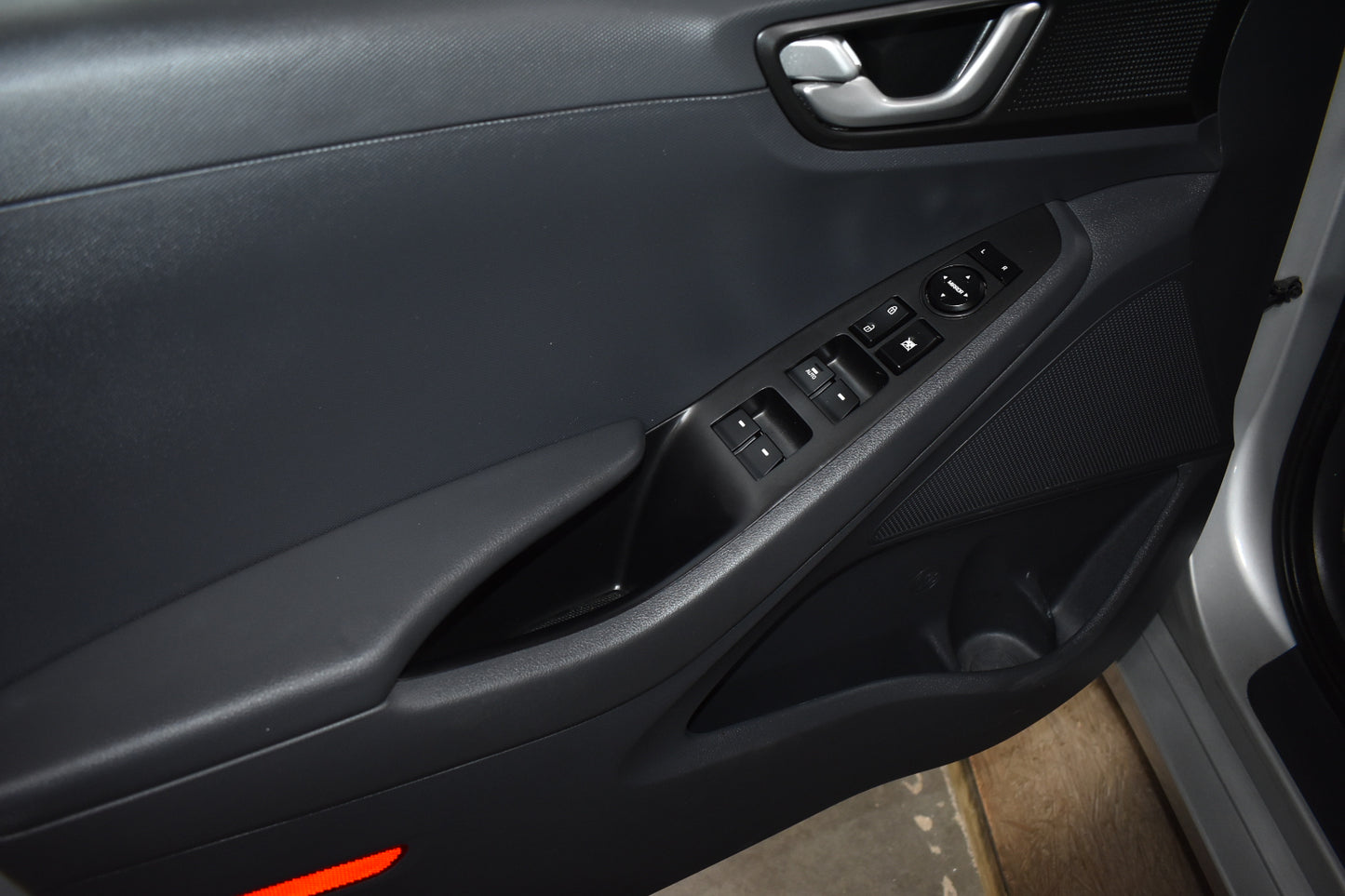 Close-up of a car door panel with controls and handle