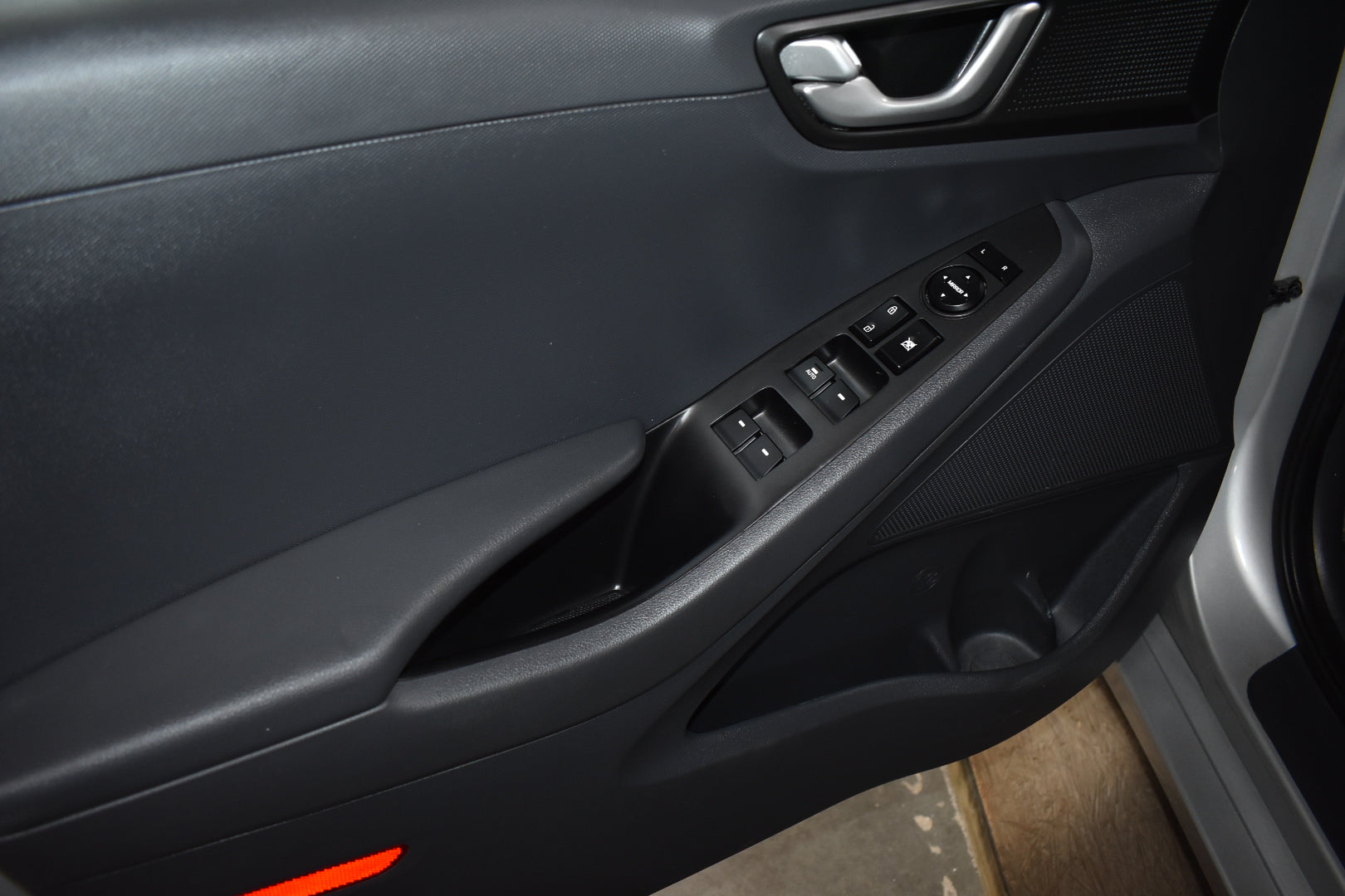 Close-up of a car door panel with controls and handle