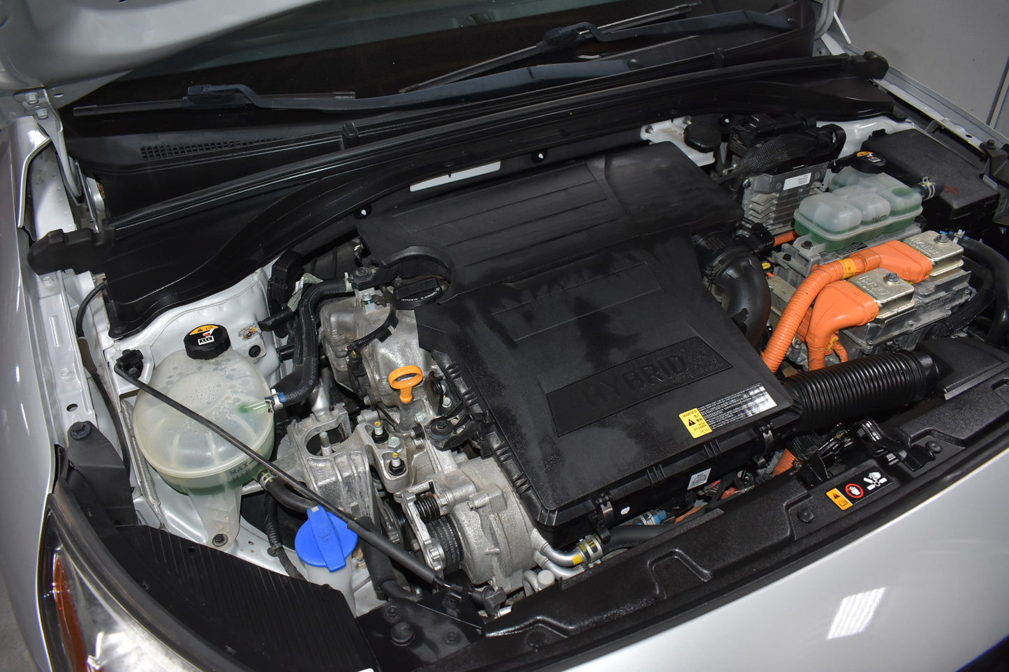 Car engine compartment with visible battery and components.