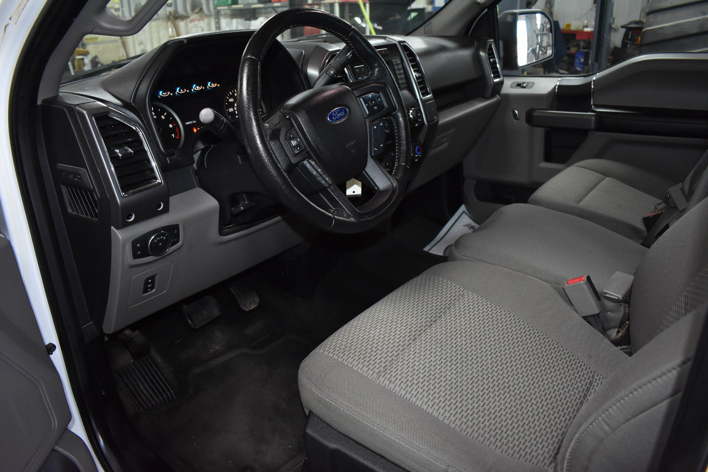 Car interior with steering wheel and dashboard in a workshop setting