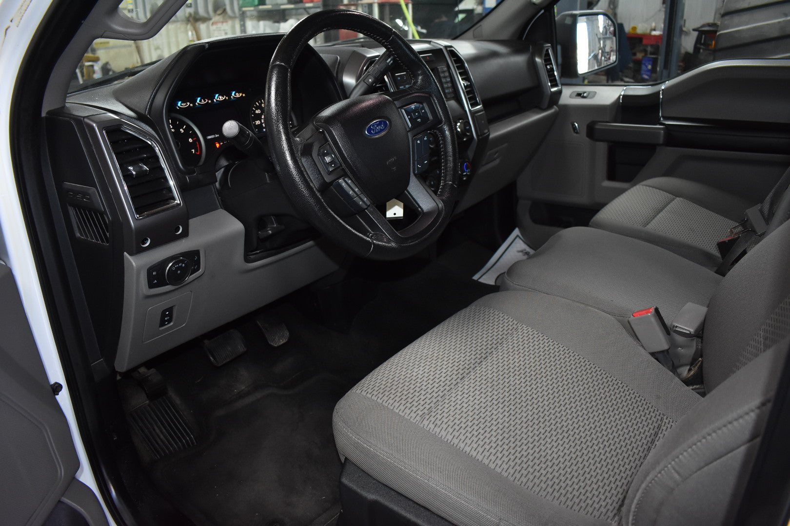 Car interior with steering wheel and dashboard in a workshop setting