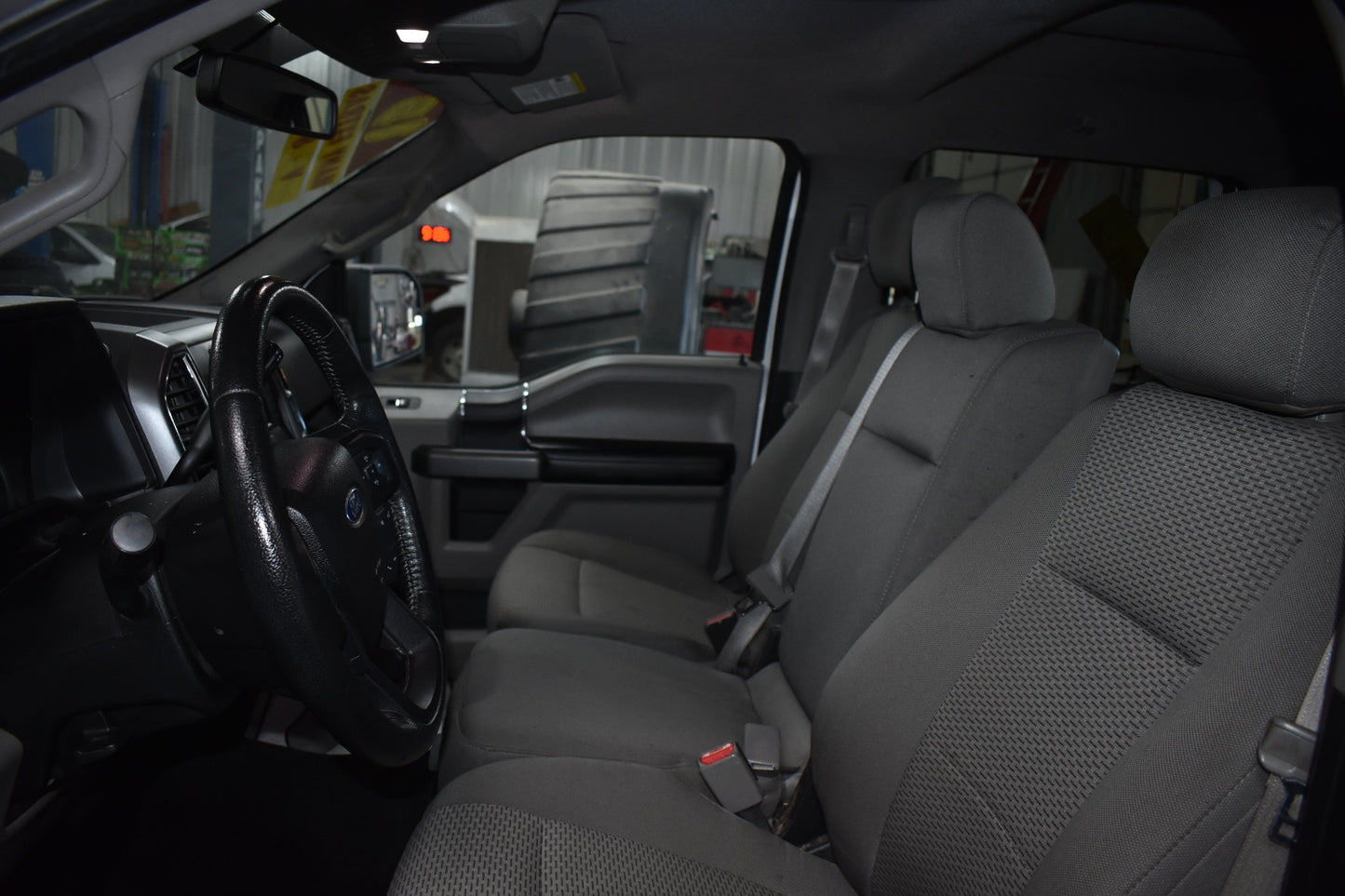 Gray car interior with steering wheel and seats in a showroom setting