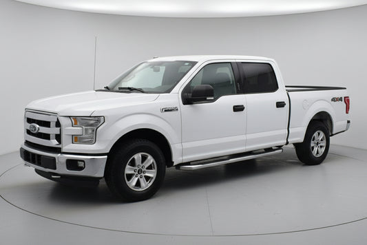 White pickup truck parked in front of a building with a wreath on the door.