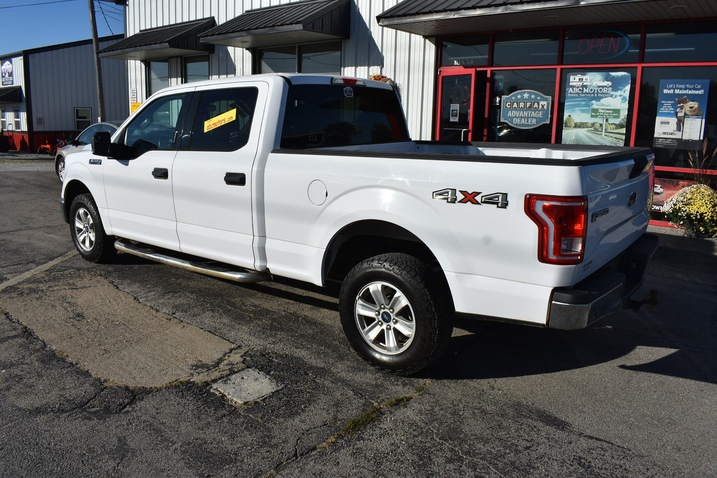 White pickup truck with '4x4' designation parked in front of a building.