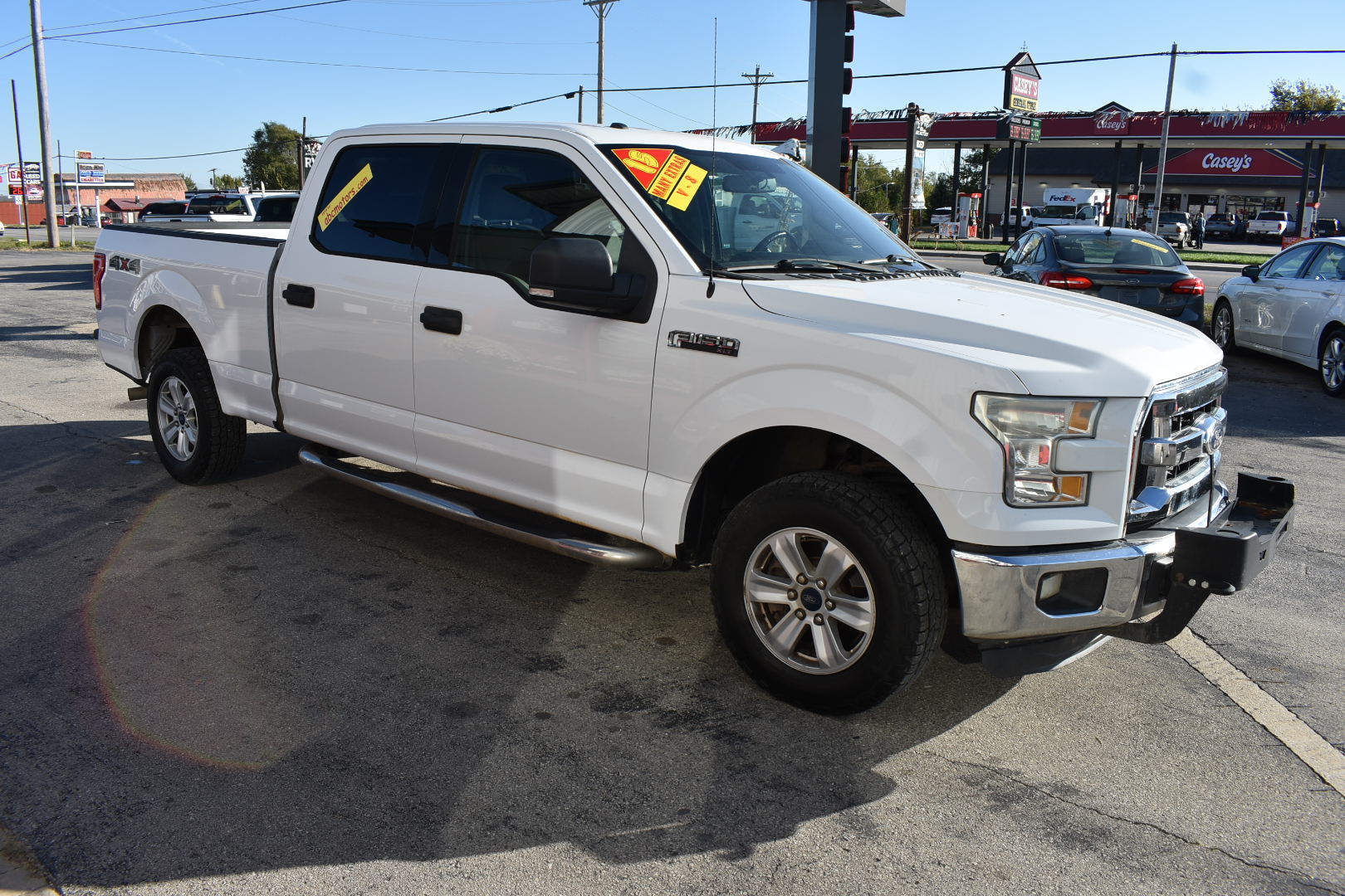 White pickup truck with sale tags in a parking lot