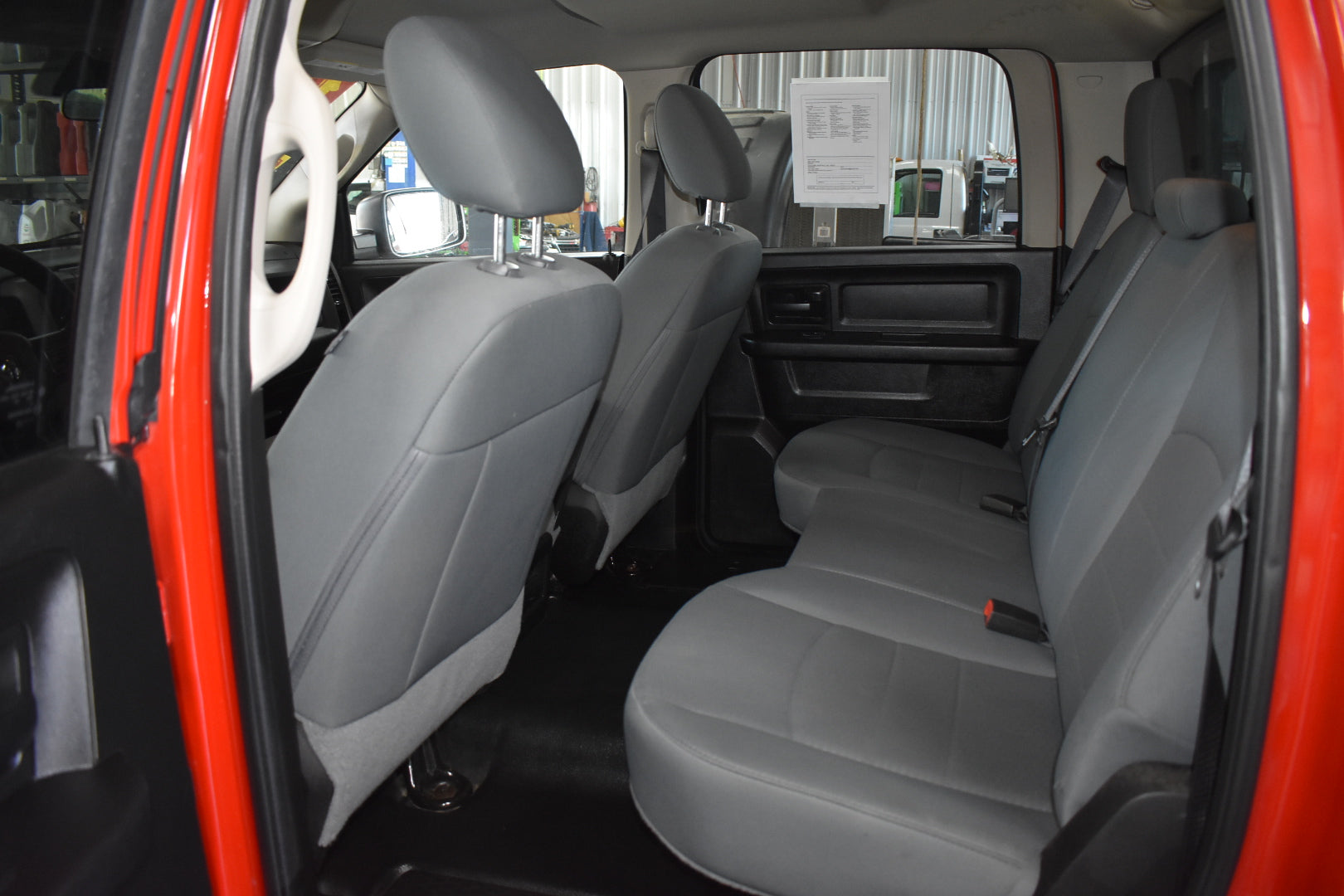 Interior of a vehicle with gray seats and open door, showing a showroom setting.