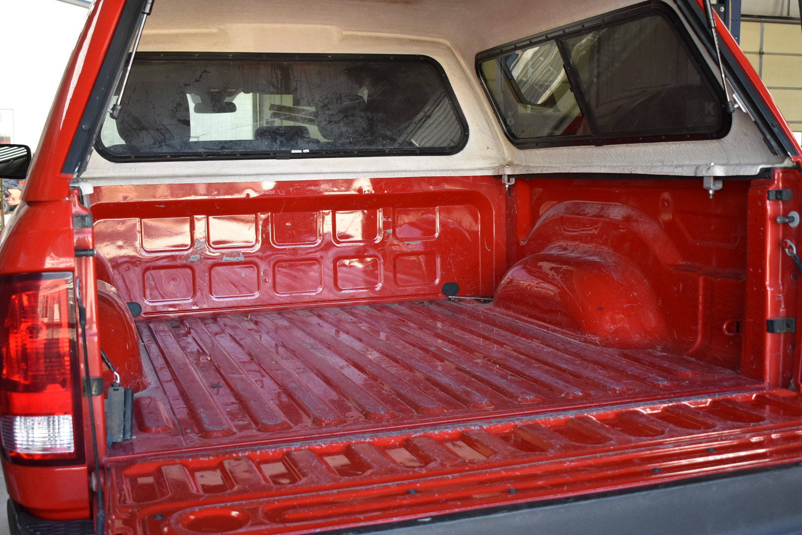 Red pickup truck bed with a white interior