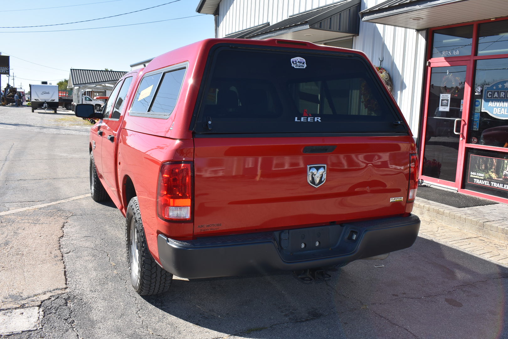 Red pickup truck parked on a street with a building in the background