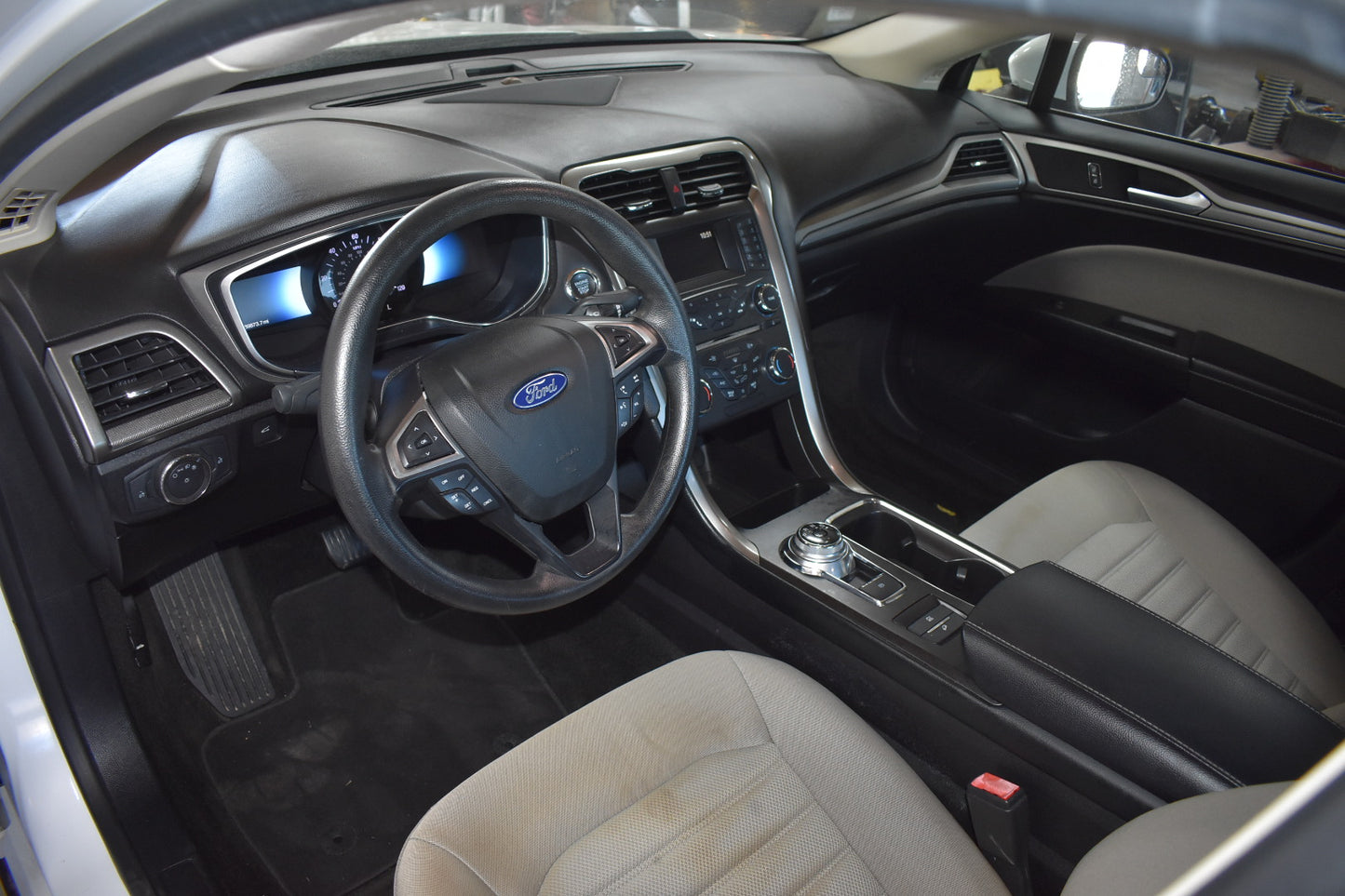 Car interior with steering wheel and dashboard featuring Ford logo