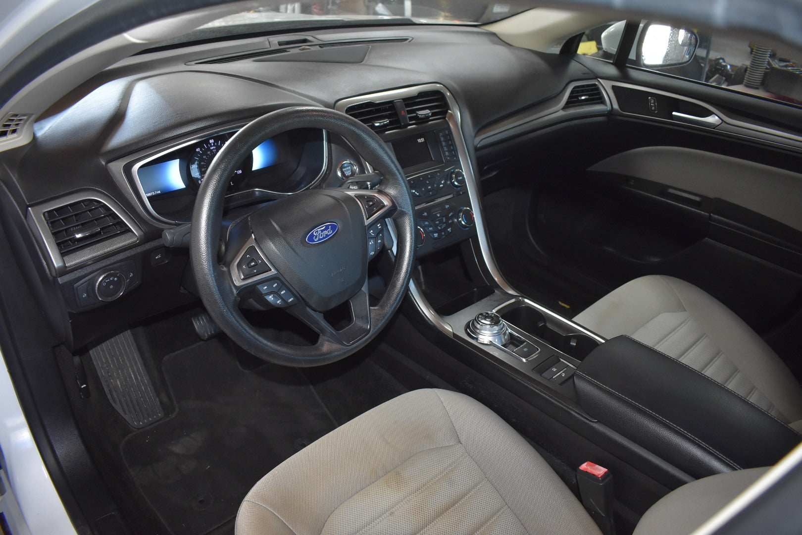 Car interior with steering wheel and dashboard featuring Ford logo