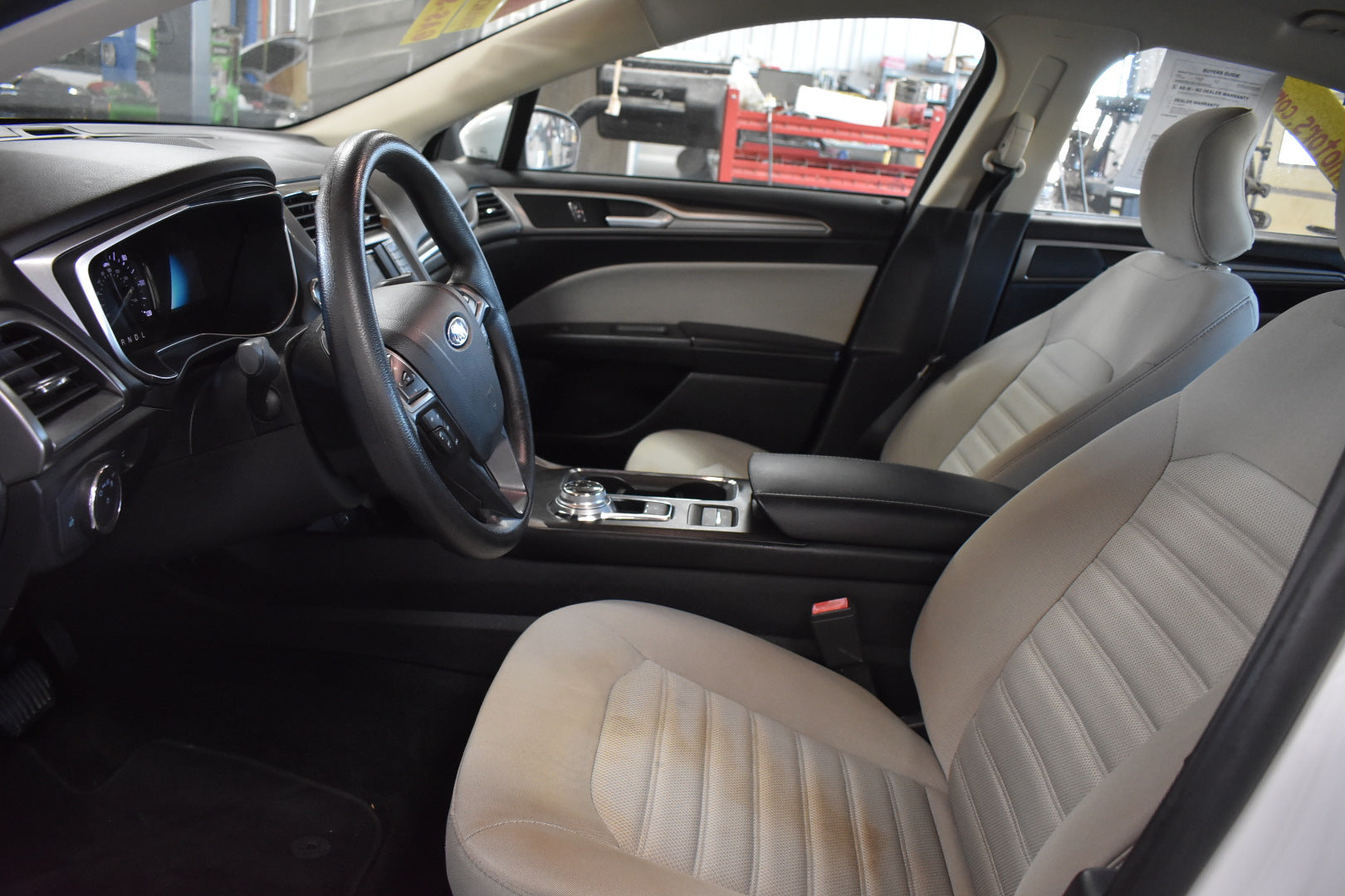 Car interior with beige seats and dashboard.