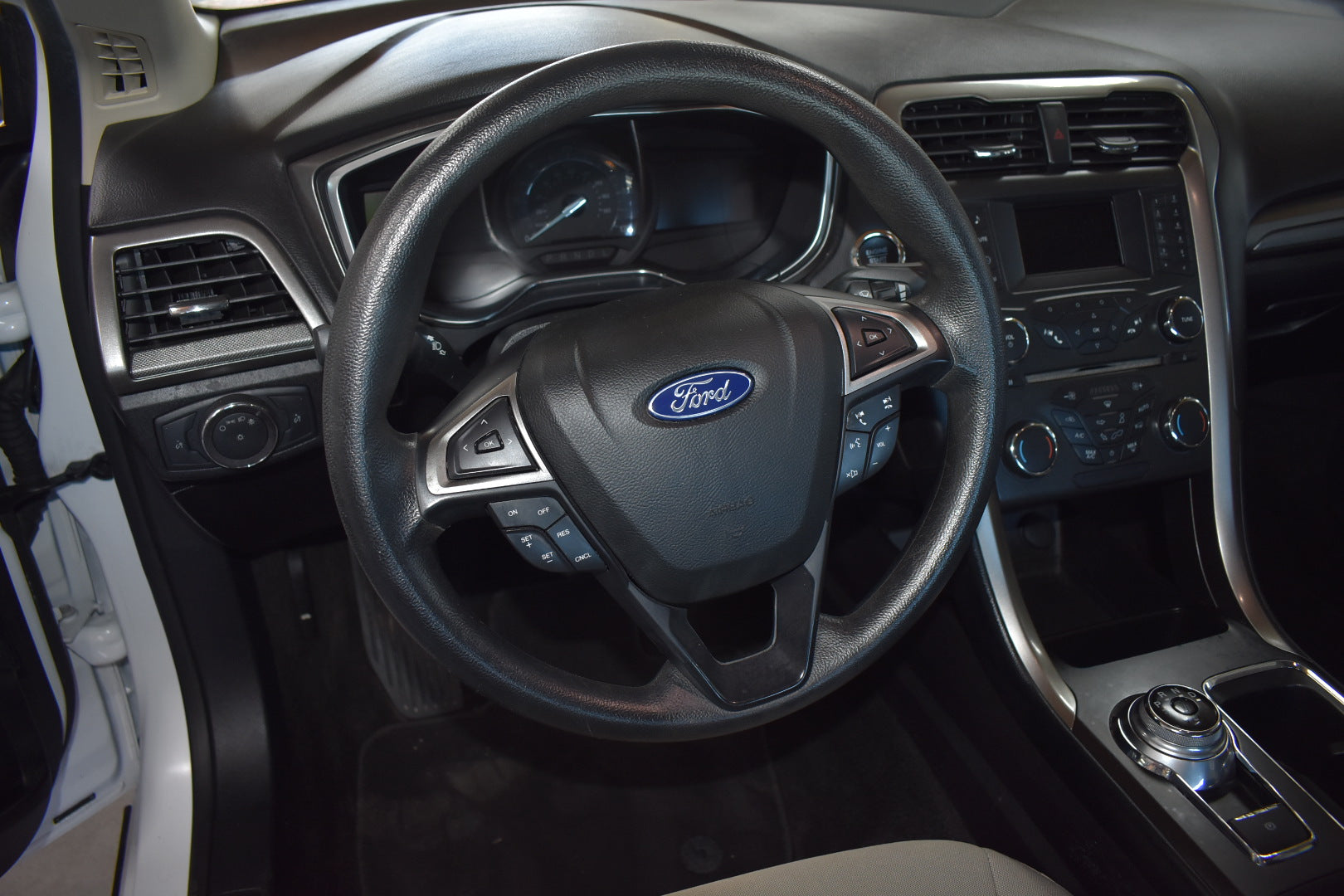 Car interior with steering wheel and dashboard featuring Ford logo