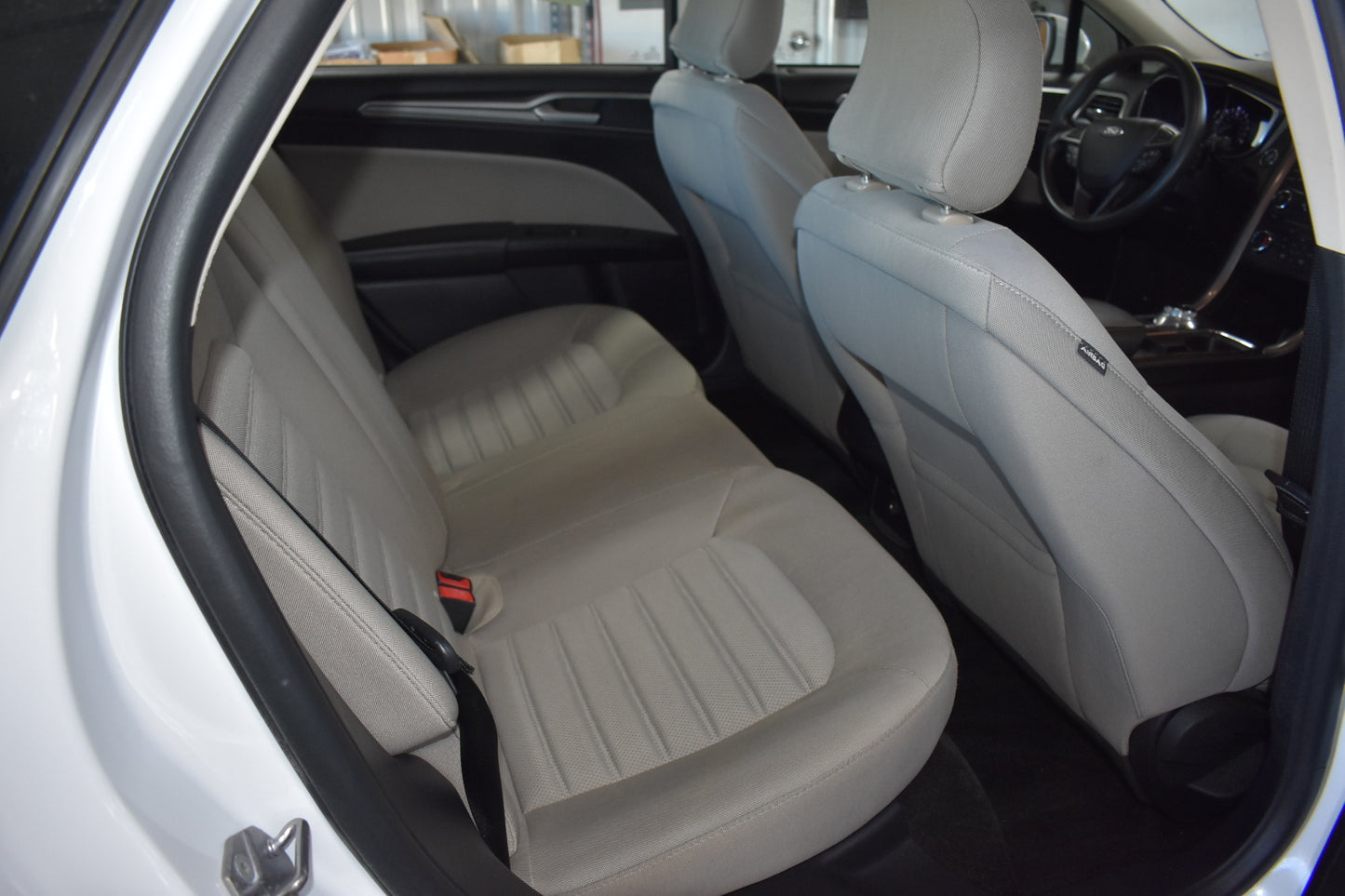 Car interior with beige seats and visible door panel.