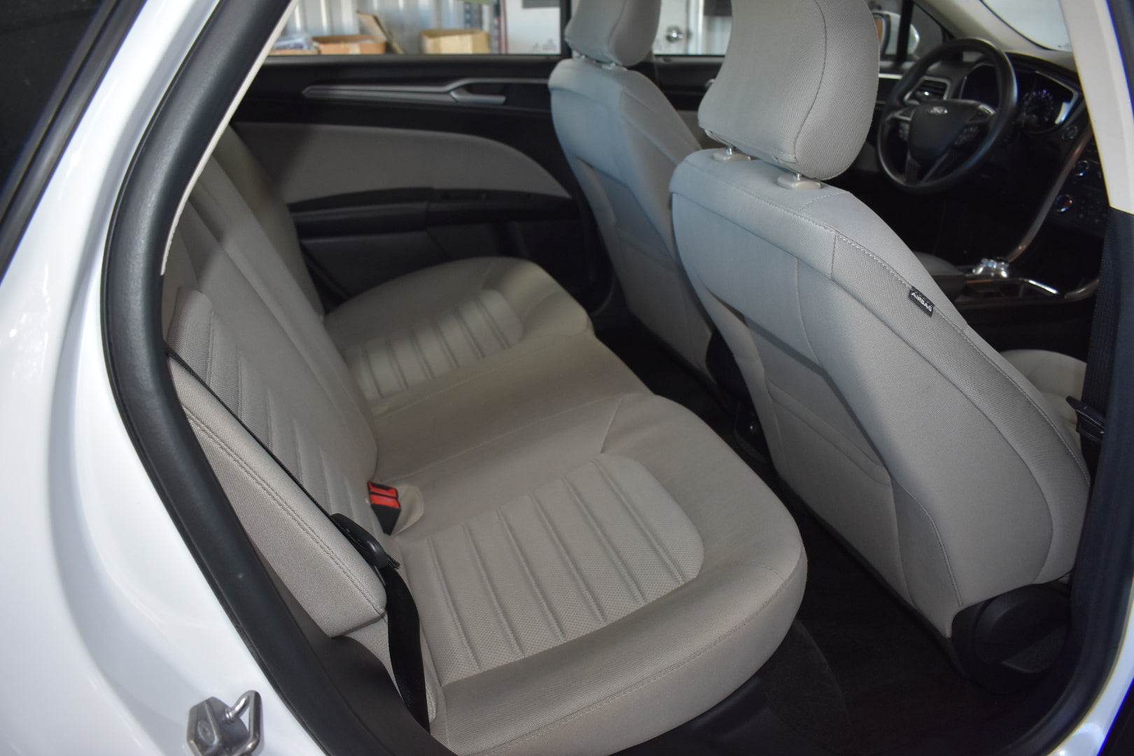 Car interior with beige seats and visible door panel.