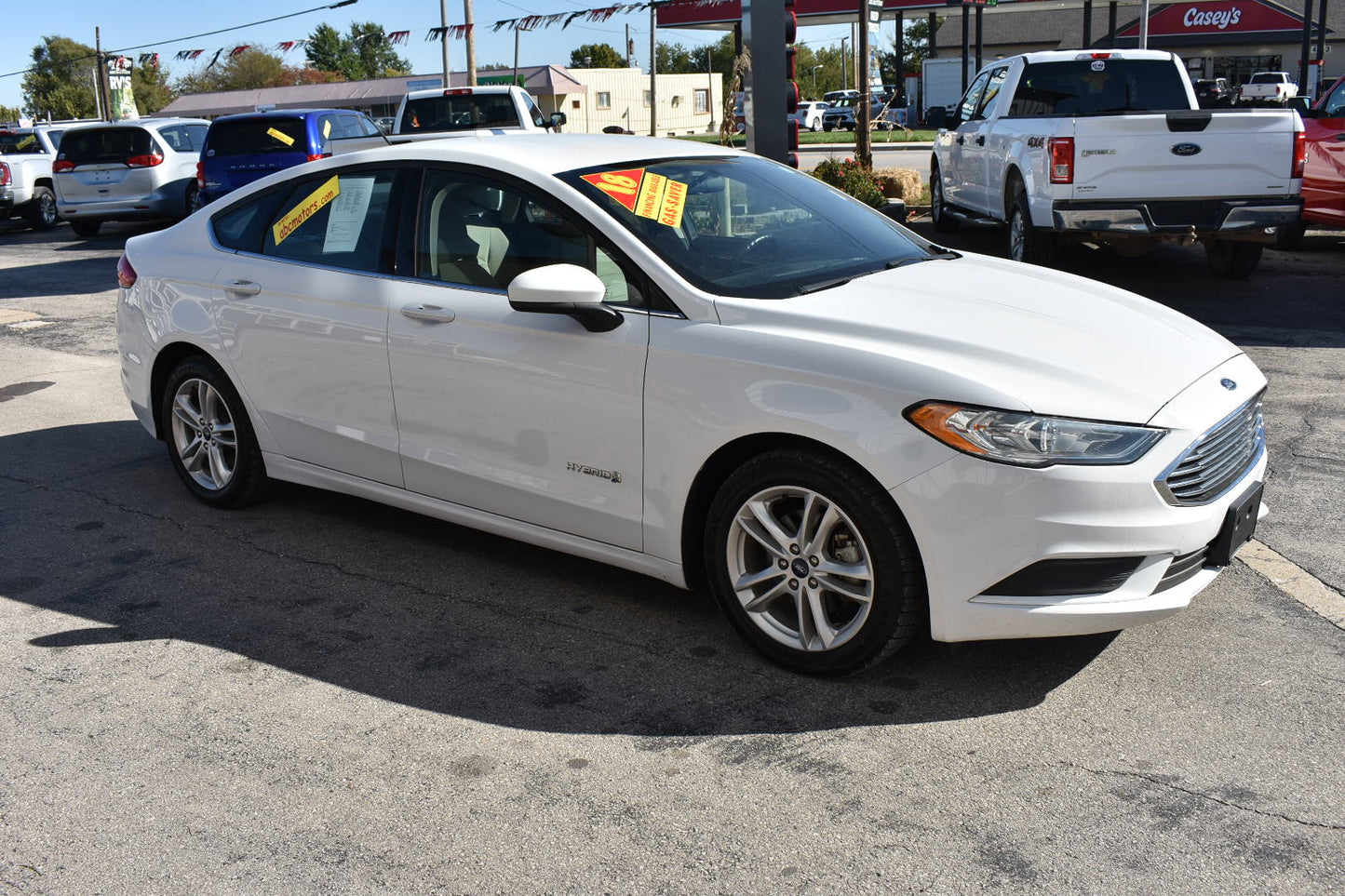White car with sale tags in a dealership lot