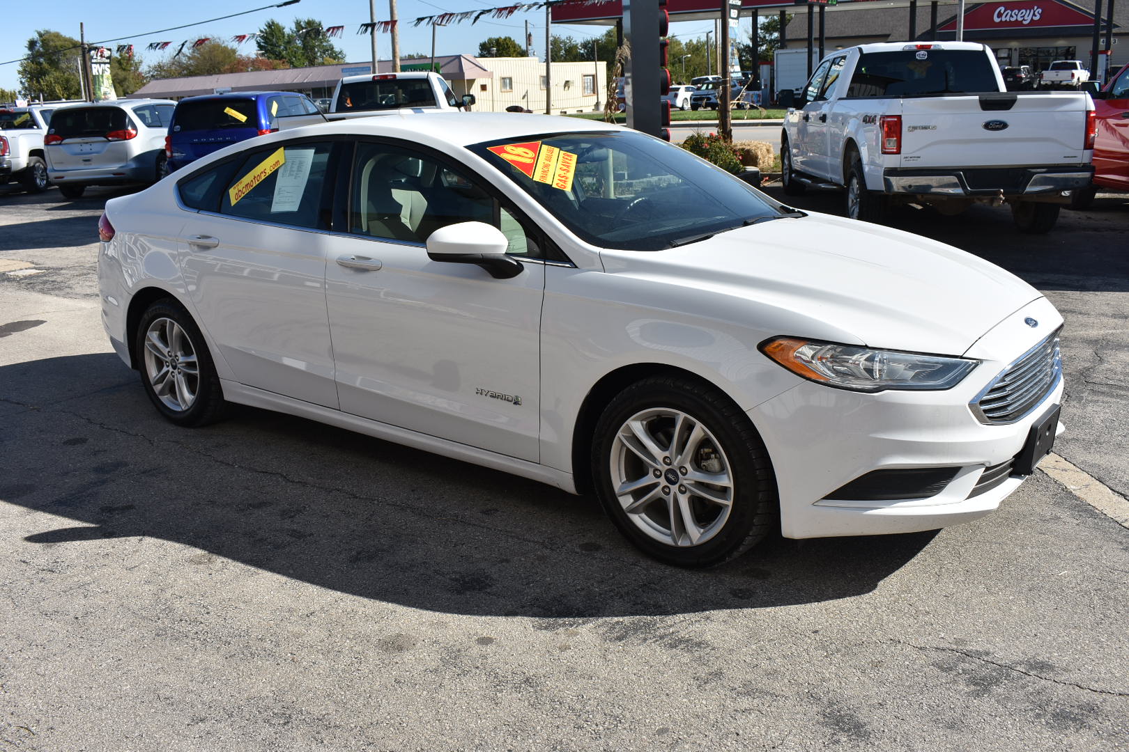 White car with sale tags in a dealership lot