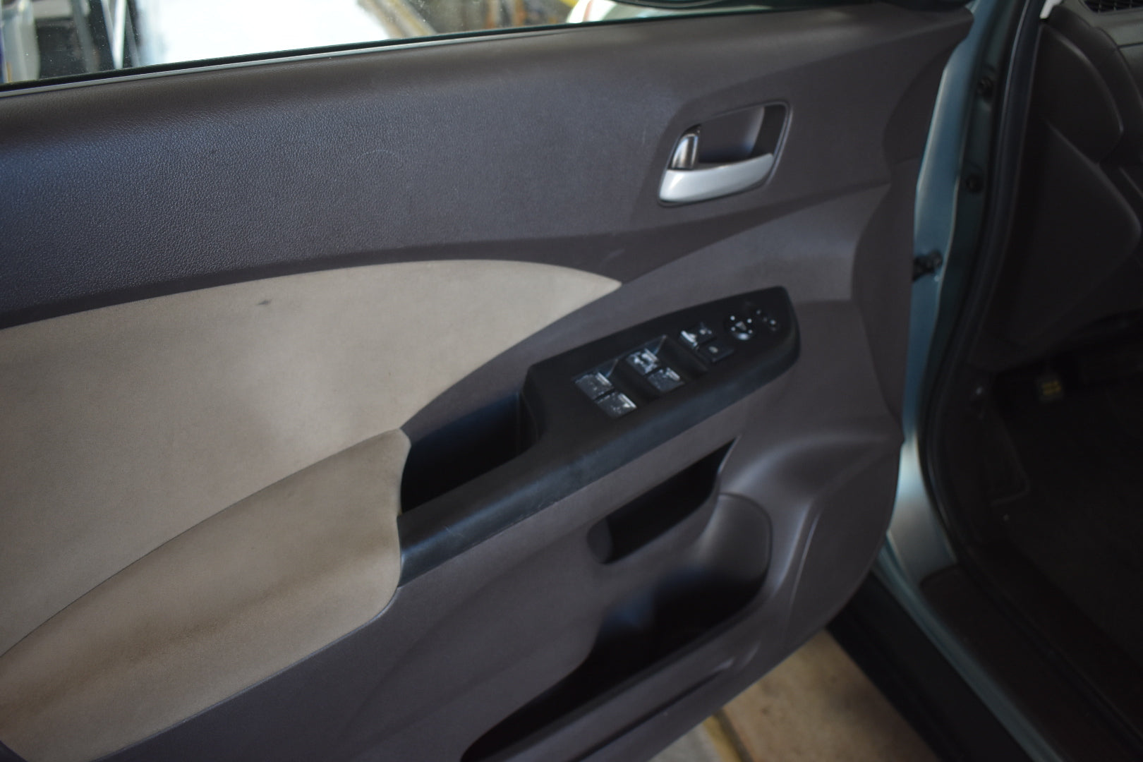 Car door interior with control panel and window controls