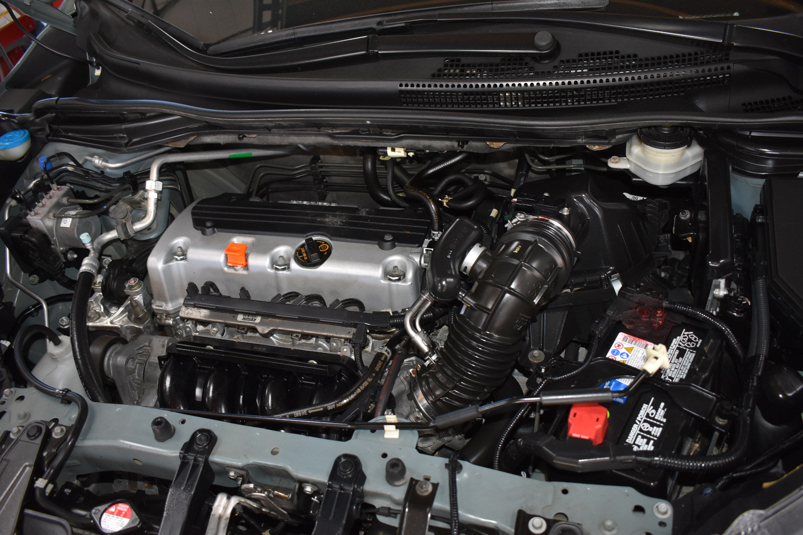 Car engine compartment with various components visible