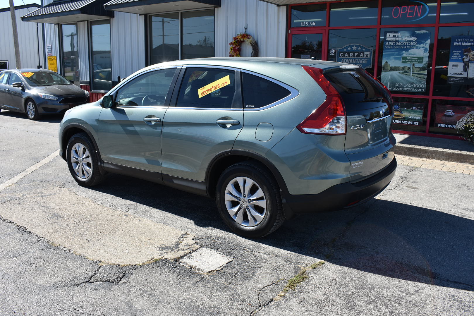 Silver SUV parked in front of a car dealership