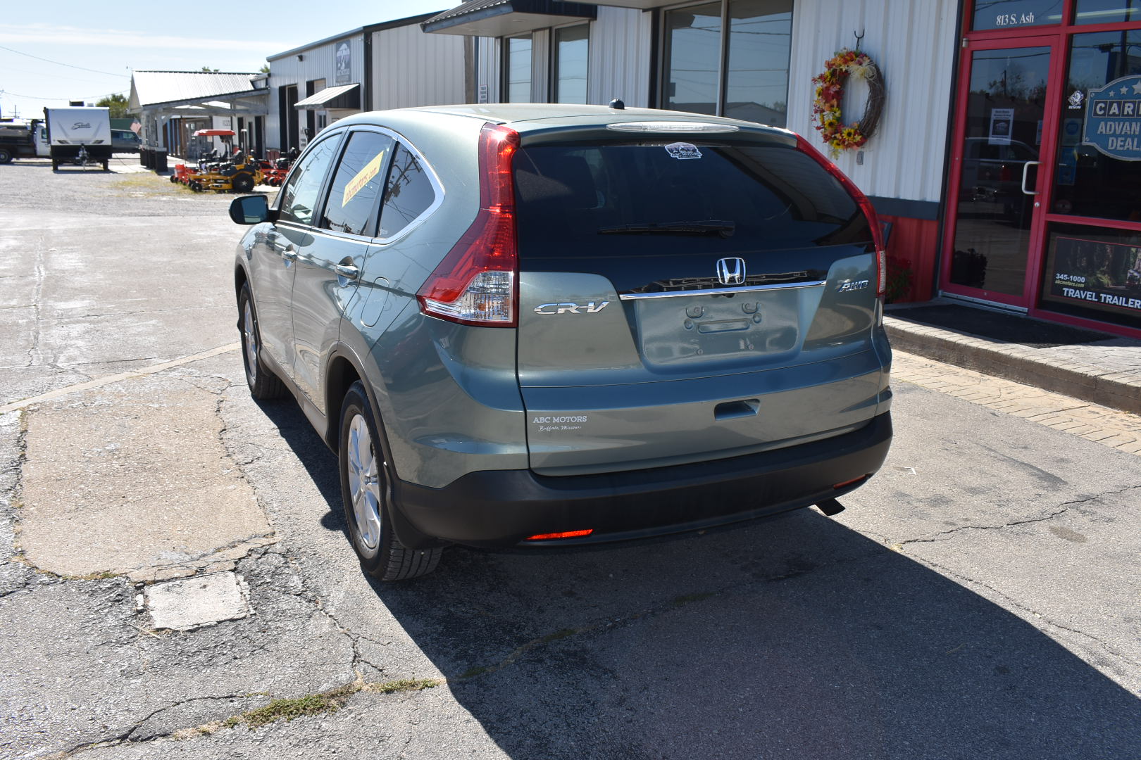 Silver Honda CR-V parked in front of a building with a wreath on the door.