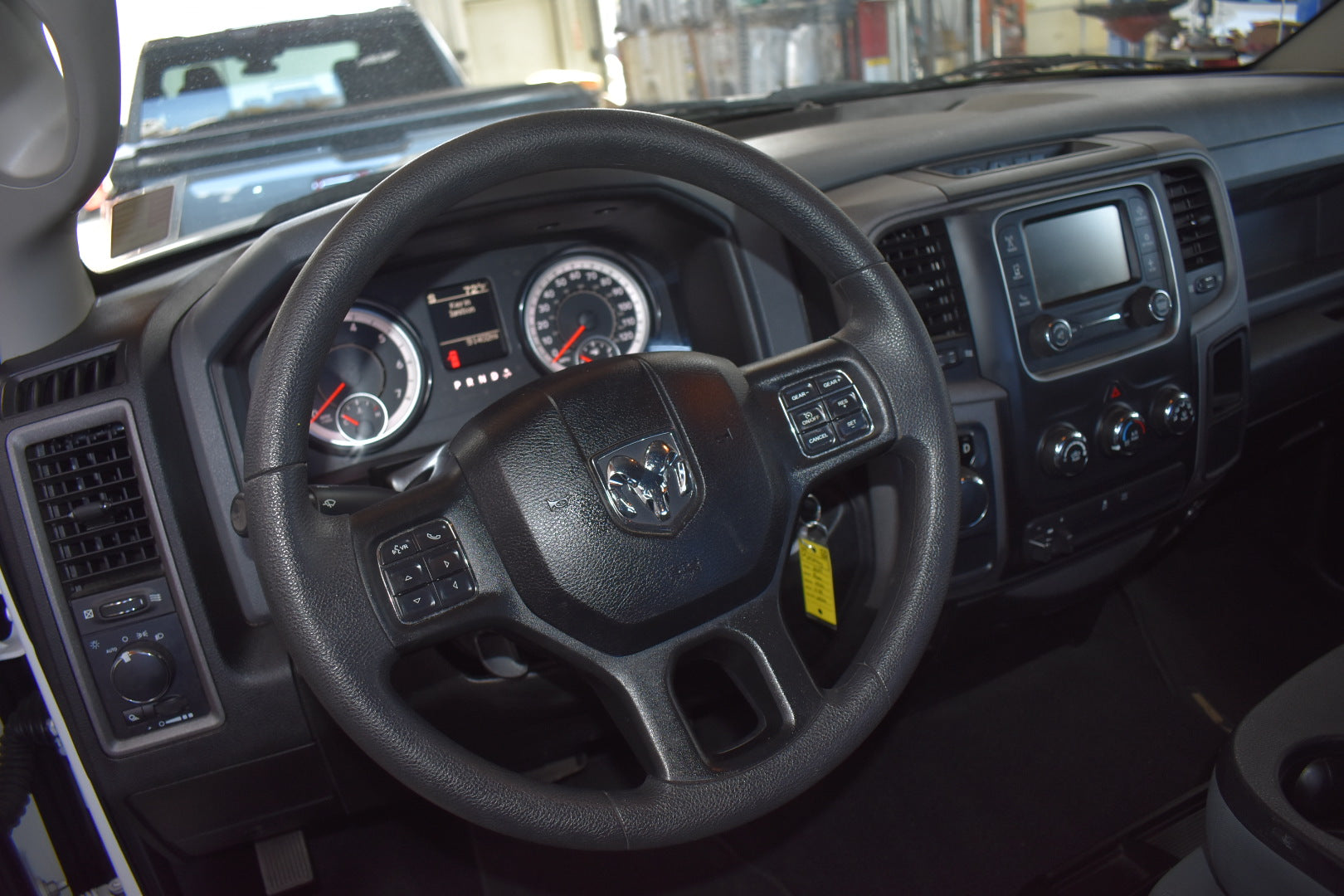 Steering wheel and dashboard of a vehicle with a visible brand logo.