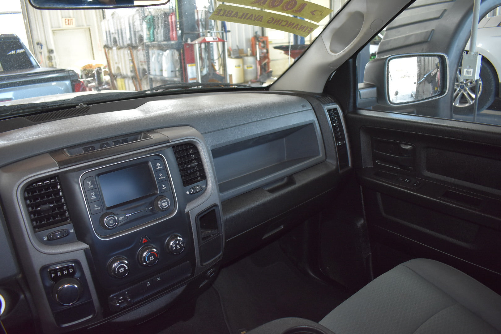 Car interior with dashboard and steering wheel in a garage setting