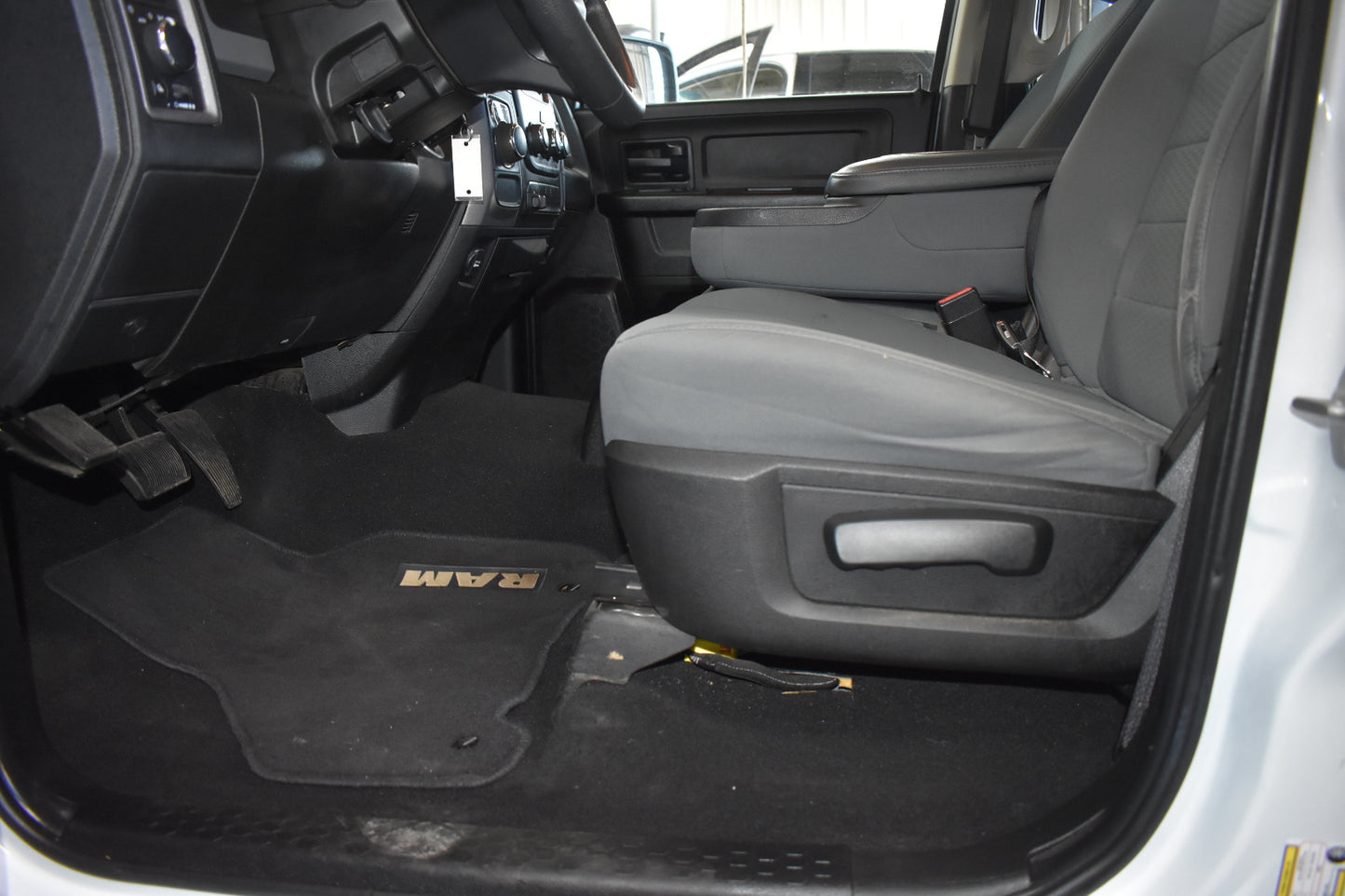 Interior of a vehicle with gray seats and a black floor mat featuring 'FORD' branding.