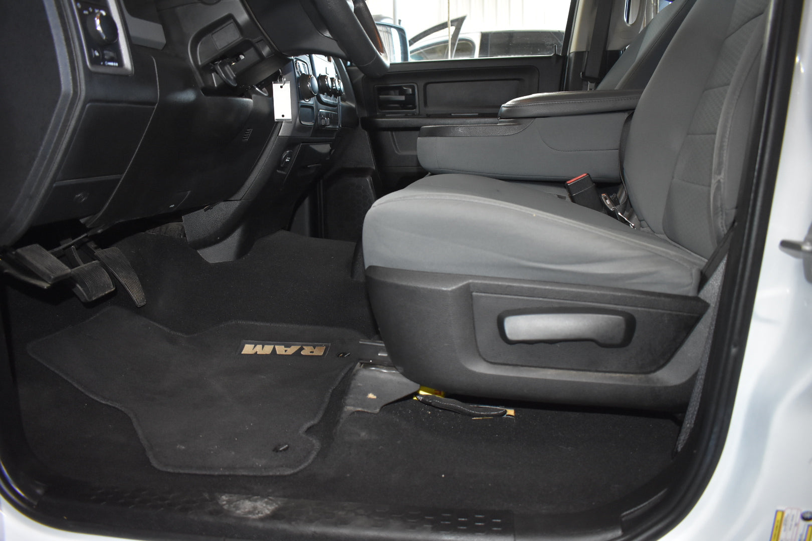 Interior of a vehicle with gray seats and a black floor mat featuring 'FORD' branding.