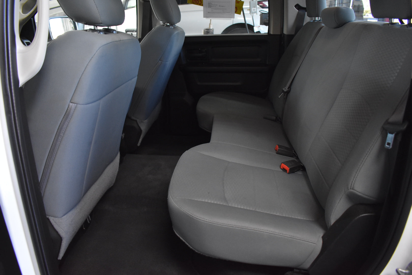 Gray car seats inside a vehicle with visible seat belts.