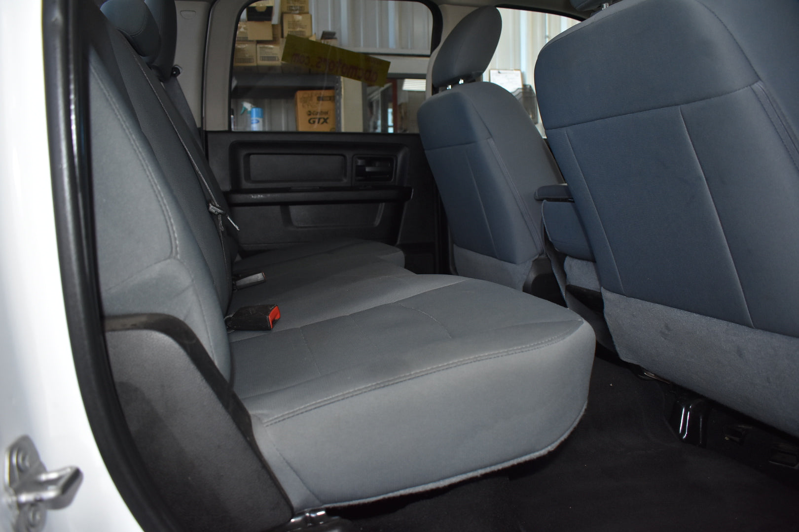 Gray car interior with open door showing backseat and cargo area.