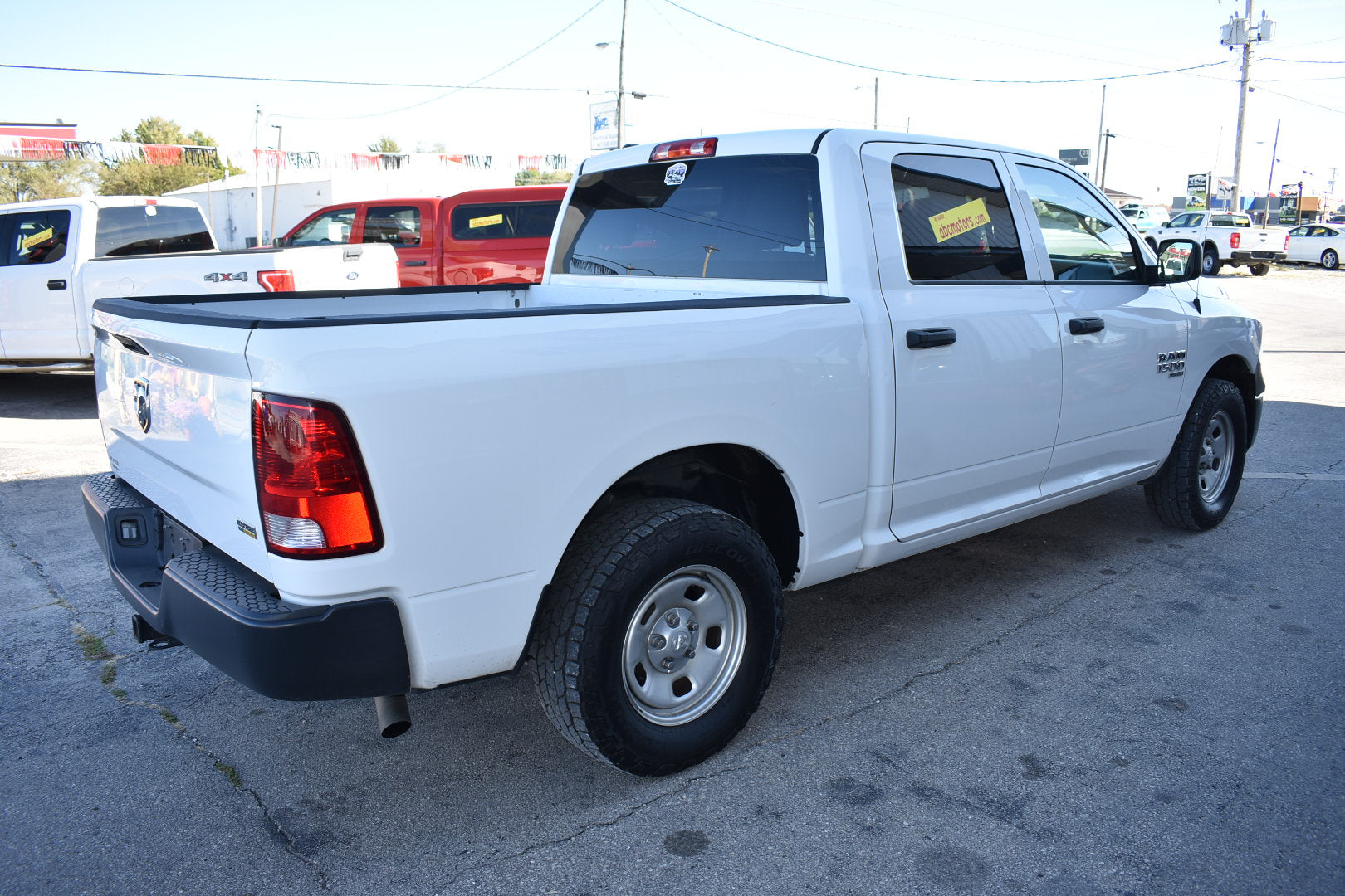 White pickup truck parked in a lot with other vehicles in the background