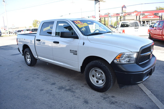White pickup truck parked on a street with a gas station in the background