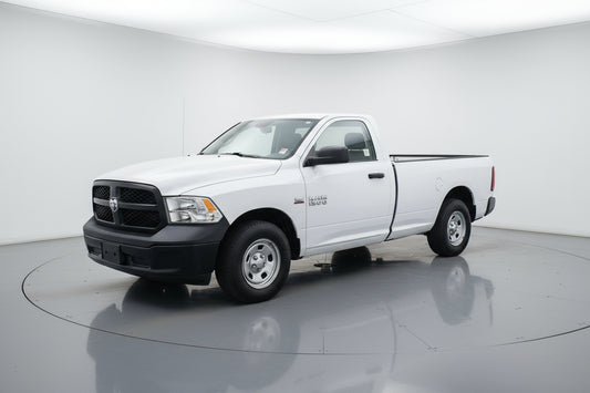 White pickup truck parked in front of a building with a wreath on the door.