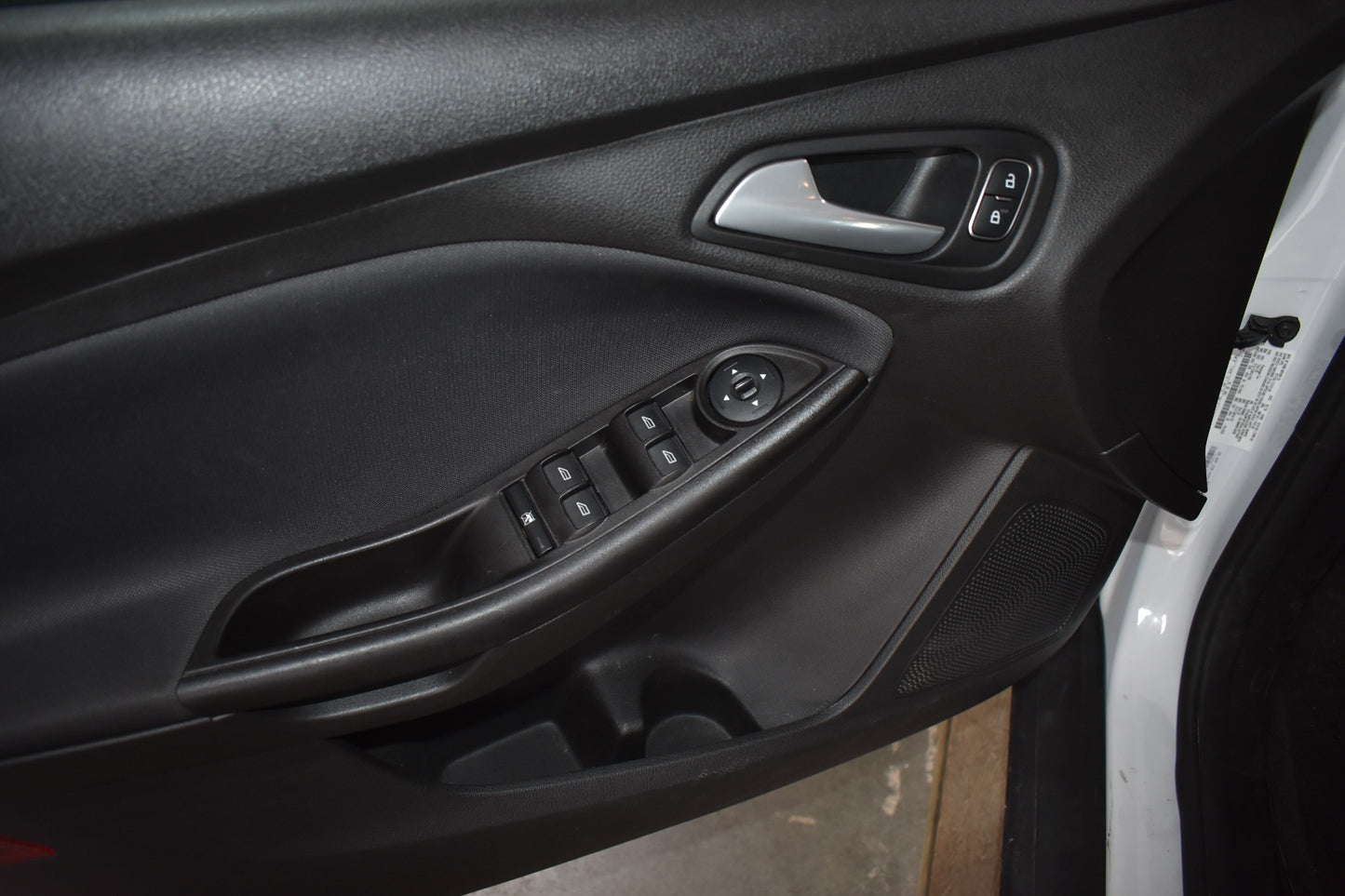Close-up of a car door panel with controls and window switch.