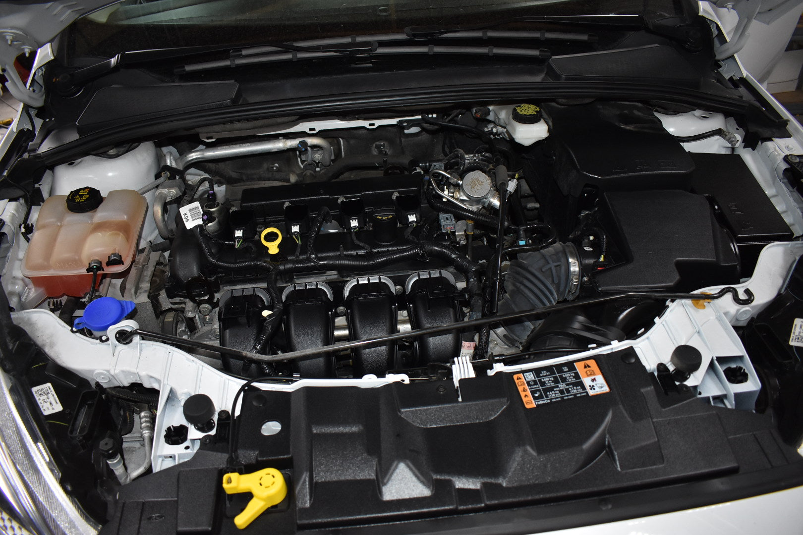 Car engine compartment with various components visible