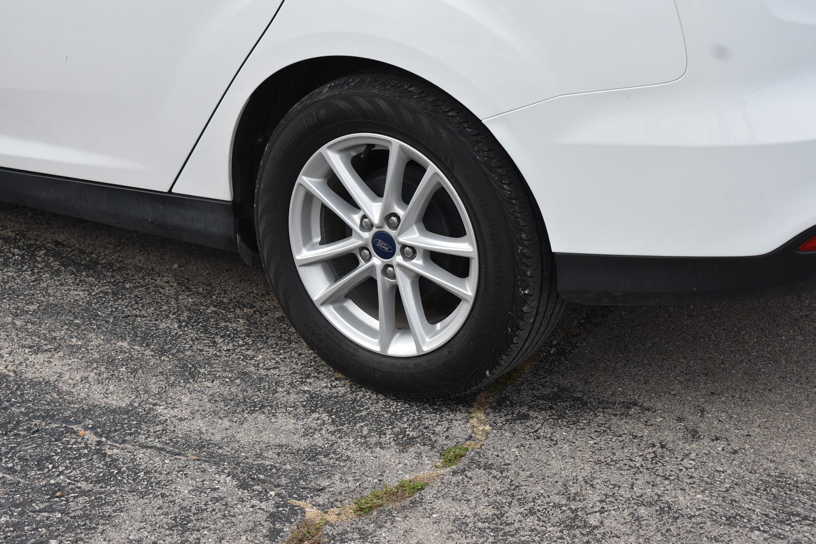 Car tire with a visible brand logo on a gray pavement