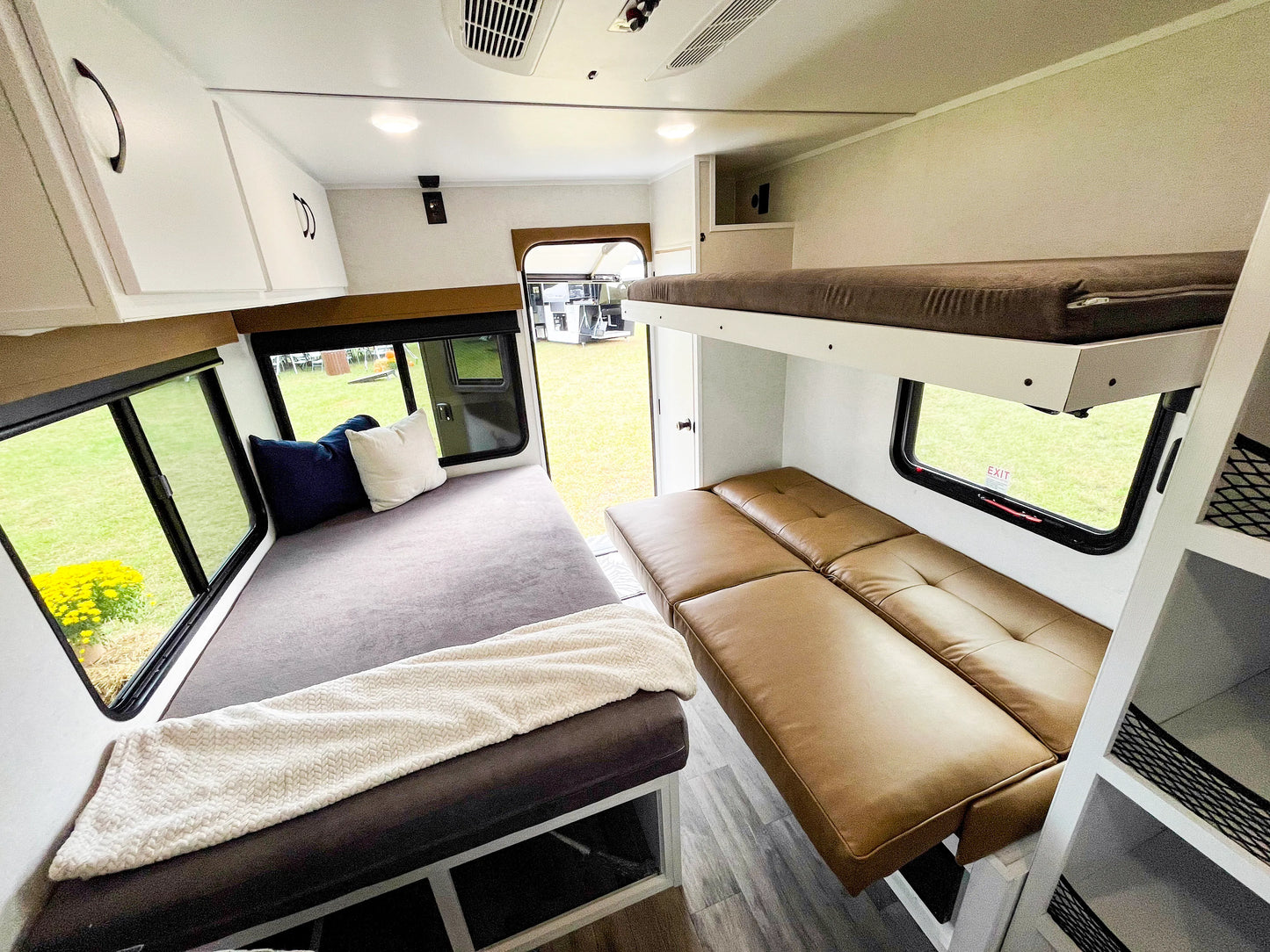 Compact living space with a bunk bed and seating area inside a vehicle or small home.