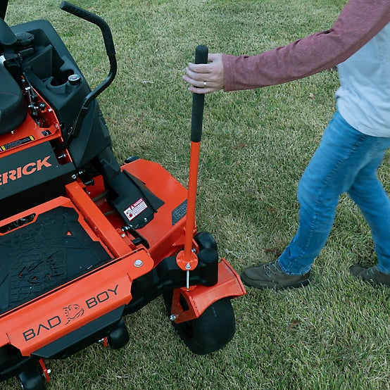 Person operating a Bad Boy lawn mower on grass