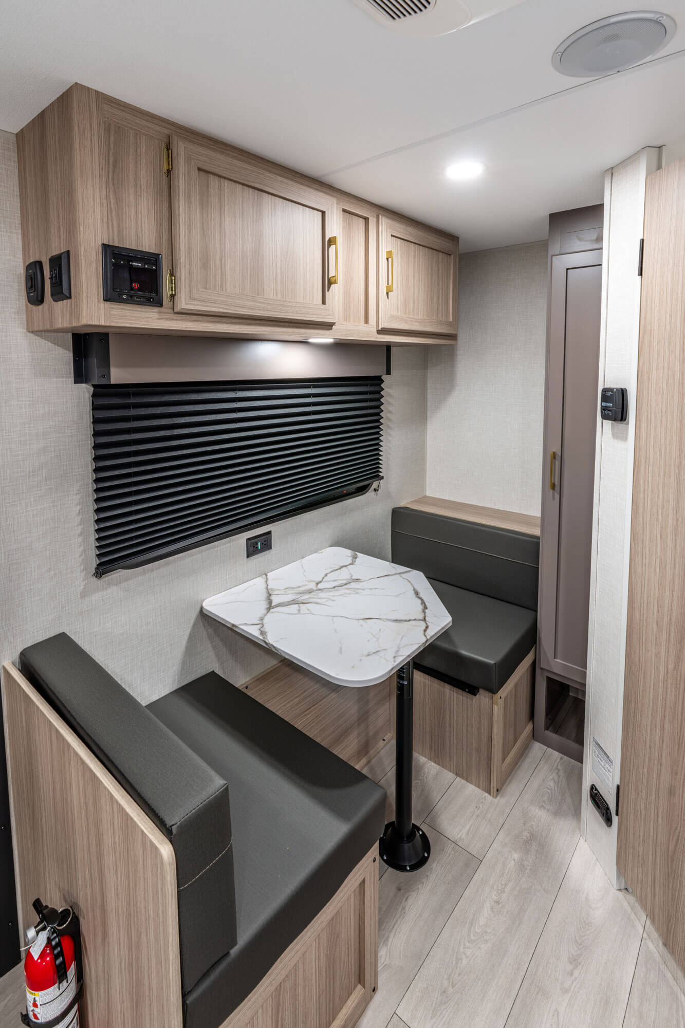 Compact interior of a vehicle with a dining table and bench seats.