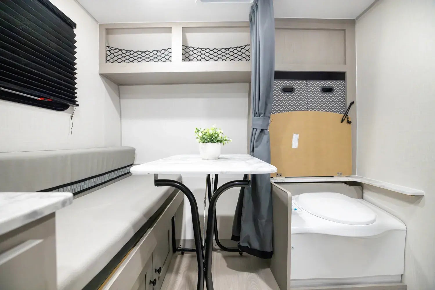 Small compact living space with a bed, desk, and storage solutions.
