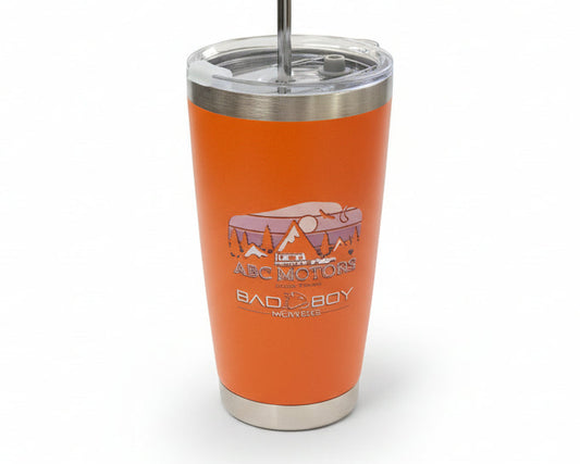 Orange tumbler with a logo on a concrete surface