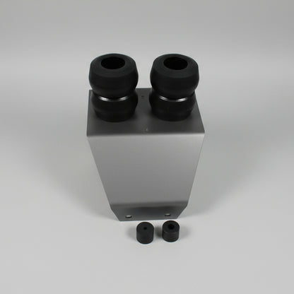 White rectangular block with black cylindrical components on a gray tiled floor