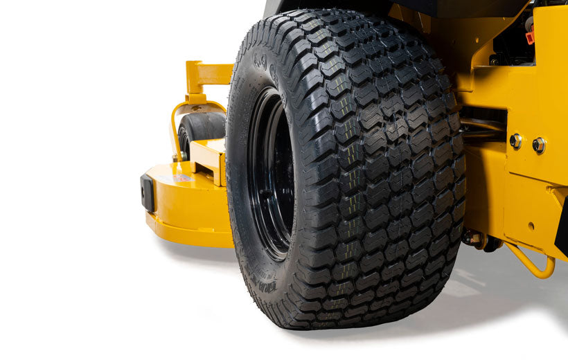 Close-up of a large black tire on a yellow piece of equipment.