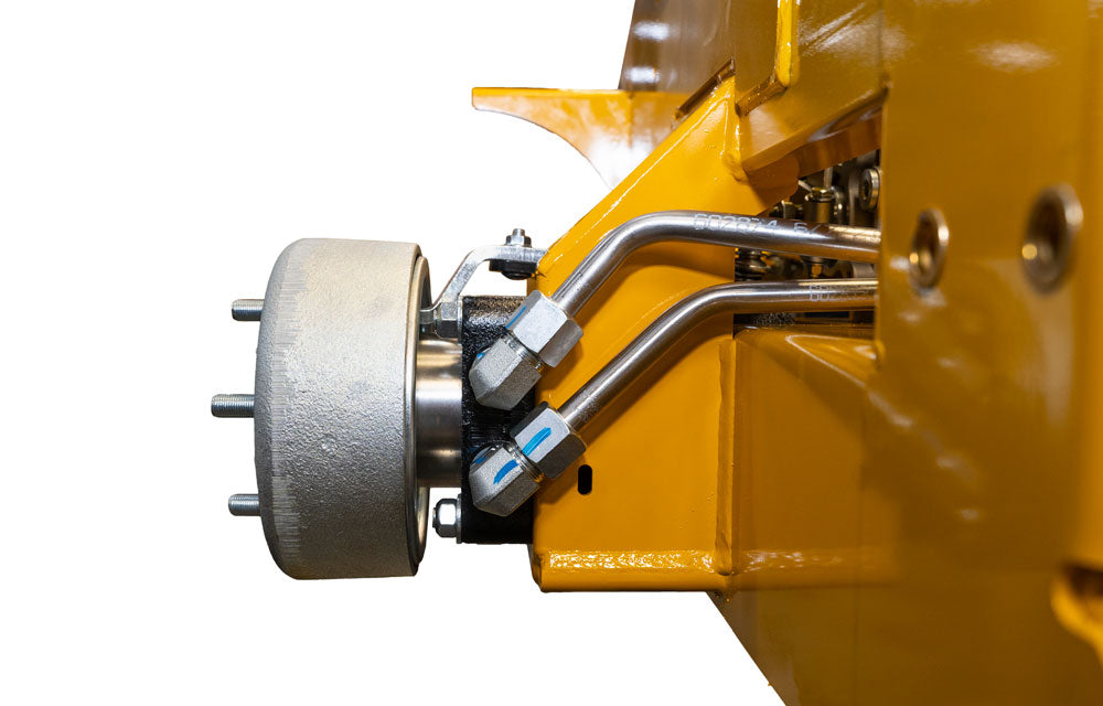 Close-up of a yellow mechanical component with metal parts on a white background